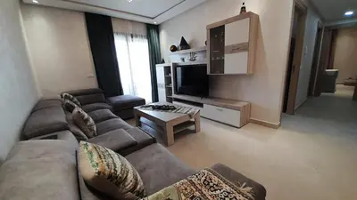 a living room with two couches and a television at Rayyan Appartement in Bouznika