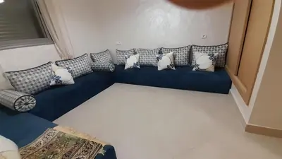 a blue couch with pillows on it in a room at Rayyan Appartement in Bouznika