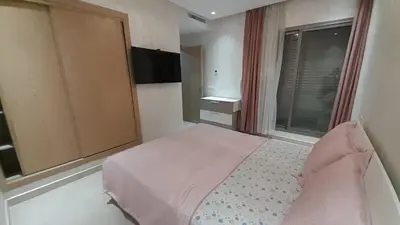 a bedroom with a bed and a large window at Rayyan Appartement in Bouznika
