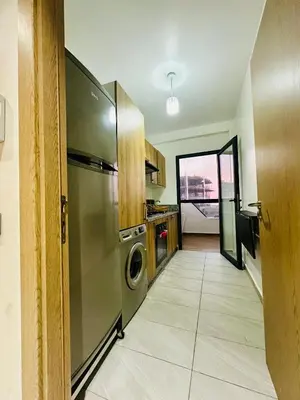 a kitchen with a stainless steel refrigerator and a dishwasher at Appartement a zenata ain-harrouda casablanca in Mohammedia