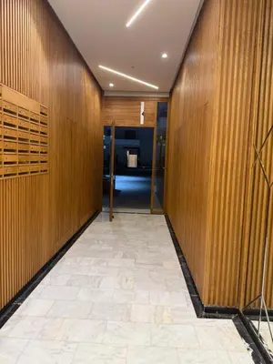 a hallway with wooden walls and a tile floor at Appartement a zenata ain-harrouda casablanca in Mohammedia