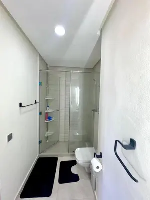 a bathroom with a glass shower and a toilet at Appartement a zenata ain-harrouda casablanca in Mohammedia