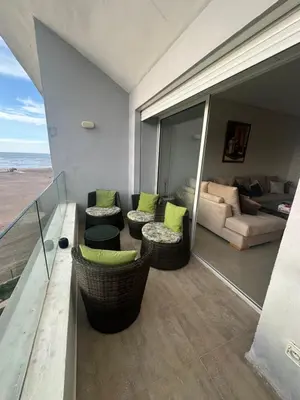 a living room with a couch and chairs on a balcony at Appartement 2 Chambres in Sidi Rahal