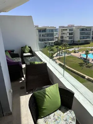 a balcony with furniture and a view of a building at Appartement 2 Chambres in Sidi Rahal