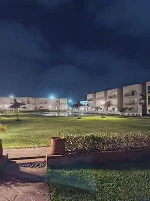 a building at night with a green field in front at Villa avec piscine, Hacienda Beach Sidi Rahal in Sidi Rahal