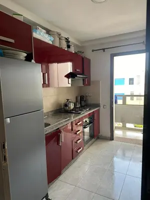 a kitchen with red cabinets and a white refrigerator at Marbella beach el mansouria in Mansouria