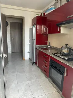 a kitchen with red cabinets and a sink and a stove at Marbella beach el mansouria in Mansouria