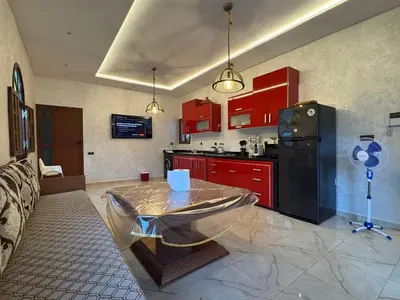a kitchen with red cabinets and a table in it at Villa Ines avec piscine privée in Sidi Moussa Ben Ali