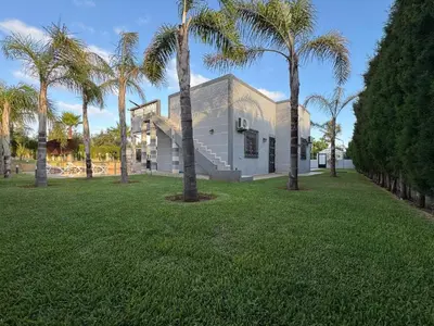 a house with palm trees in a park at Villa Ines avec piscine privée in Sidi Moussa Ben Ali