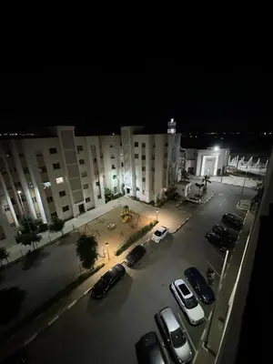 a parking lot with cars parked in front of a building at Séjour confortable, Plage Skhirat in Skhirat