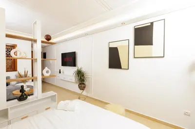 a bedroom with white walls and a bed and a mirror at Luxury 1BR with Charming Balcony - Romantic Getaway in Rabat