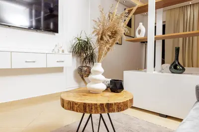 a table with a vase on top of it in a living room at Luxury 1BR with Charming Balcony - Romantic Getaway in Rabat