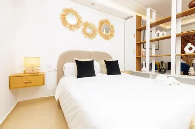 a bedroom with a white bed with two mirrors on the wall at Luxury 1BR with Charming Balcony - Romantic Getaway in Rabat