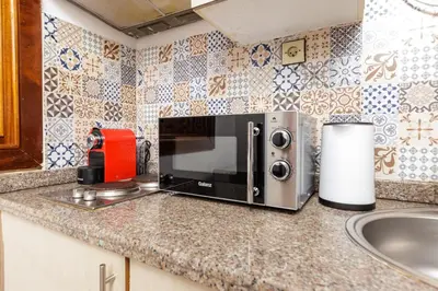 a kitchen counter with a microwave and a sink at Luxury 1BR with Charming Balcony - Romantic Getaway in Rabat