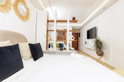 a bedroom with a large white bed and a tv at Luxury 1BR with Charming Balcony - Romantic Getaway in Rabat