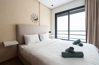 a bedroom with a large white bed with a large window at Oasis 9 Cozy studio in Downtown Maarif in Casablanca
