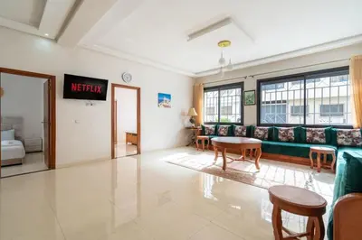 a living room with a couch and a table at Appartement Proche Plage in Bouznika
