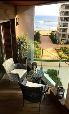 a balcony with a table and chairs and a view of the ocean at Marina Ocean Suite - By Appart'Ayla in Casablanca