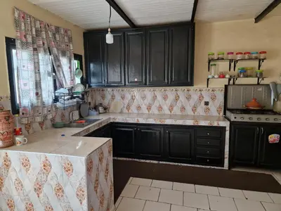 a kitchen with black cabinets and a counter top at Élégance et Confort à Ain Sebaa, Commodité,Plages in Casablanca