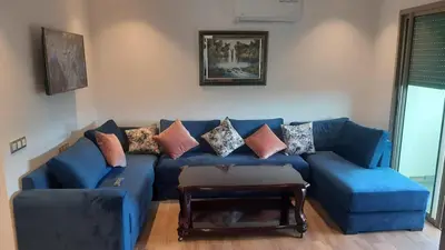 a blue couch with pillows on it in a living room at blue beach in Sidi Rahal