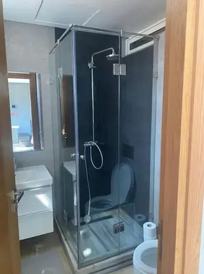 a bathroom with a glass shower with a toilet at Villa avec piscine Mohammedia in Mohammedia