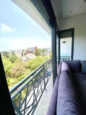 a living room with a couch on a balcony at Luxury studio center Abdelmoumen 1min tram with view in Casablanca