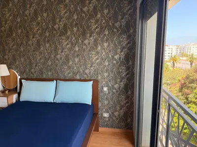 a bedroom with a blue bed and a balcony at Luxury studio center Abdelmoumen 1min tram with view in Casablanca