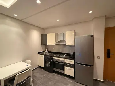 a kitchen with a stove and a refrigerator at Luxury studio center Abdelmoumen 1min tram with view in Casablanca