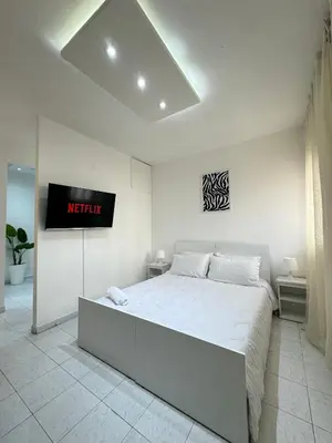 a bedroom with a bed with a tv on the wall at SUITOUISS - Agdal - Studio en plein cœur de Rabat à 5 minutes du grand mall Arribat Center - centre ville in Rabat