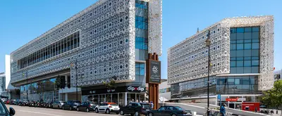 two tall buildings with cars parked on a city street at SUITOUISS - Agdal - Studio en plein cœur de Rabat à 5 minutes du grand mall Arribat Center - centre ville in Rabat