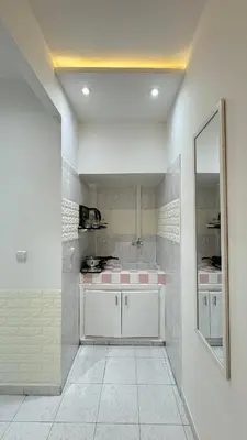 a kitchen with white cabinets and a large mirror at SUITOUISS - Agdal - Studio en plein cœur de Rabat à 5 minutes du grand mall Arribat Center - centre ville in Rabat