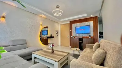 a living room with a couch and a table at Prestigia Hay Riad, Appartement Moderne au Style Chic in Rabat