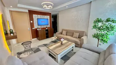 a living room with two couches and a tv at Prestigia Hay Riad, Appartement Moderne au Style Chic in Rabat