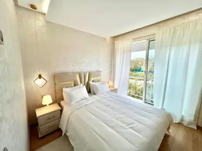 a bedroom with a large white bed with a window at Prestigia Hay Riad, Appartement Moderne au Style Chic in Rabat