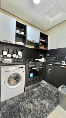 a kitchen with a washing machine and a sink at Prestigia Hay Riad, Appartement Moderne au Style Chic in Rabat