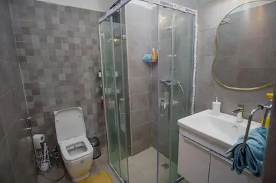 a bathroom with a shower and a toilet and a sink at Relax toute l'année Piscine chauffée in Temara