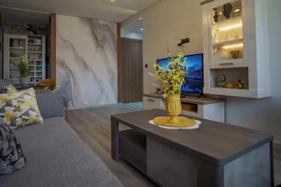 a living room with a vase of flowers on a coffee table at Relax toute l'année Piscine chauffée in Temara