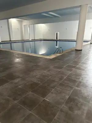 an empty room with a tile floor and a pool at Relax toute l'année Piscine chauffée in Temara