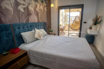 a bedroom with a large bed with a blue headboard at Relax toute l'année Piscine chauffée in Temara