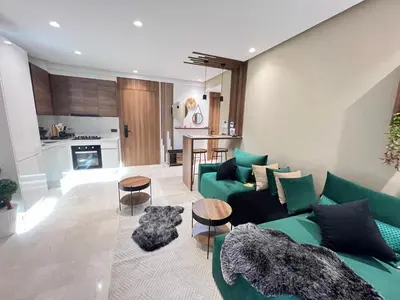 a living room with a green couch and a kitchen at Studio4 Comfortable rest in Casablanca