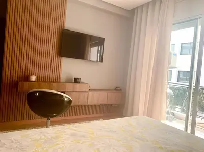 a bedroom with a bed and a television on the wall at Appartementperle in Casablanca
