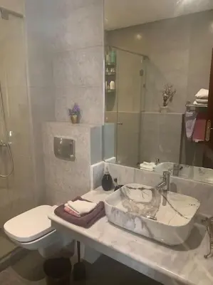 a bathroom with a sink and a toilet and a mirror at Appartementperle in Casablanca