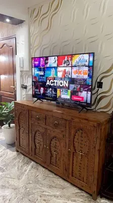 a flat screen tv on top of a wooden entertainment center at Elegant and Comfortable Apartment in the Heart of Rabat in Rabat