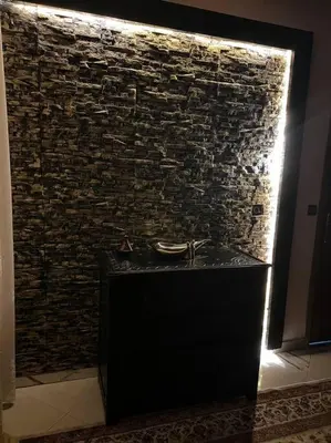 a bathroom with a stone wall with a sink at Elegant and Comfortable Apartment in the Heart of Rabat in Rabat