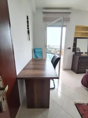 a wooden desk in a room with a balcony at Paradis Avec Vue Harhoura in El Harhoura