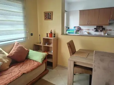 a living room with a couch and a table and a kitchen at Paradis Avec Vue Harhoura in El Harhoura