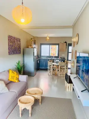 a living room with a couch and a kitchen at Nice Apartment near airport mohammed V International Casablanca in Deroua