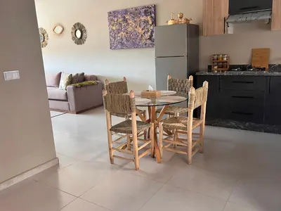 a kitchen with a table and chairs in a room at Nice Apartment near airport mohammed V International Casablanca in Deroua