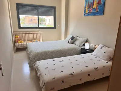 a bedroom with two beds and a crib in it at Nice Apartment near airport mohammed V International Casablanca in Deroua