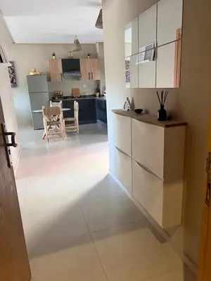 a kitchen with white cabinets and a dining room at Nice Apartment near airport mohammed V International Casablanca in Deroua